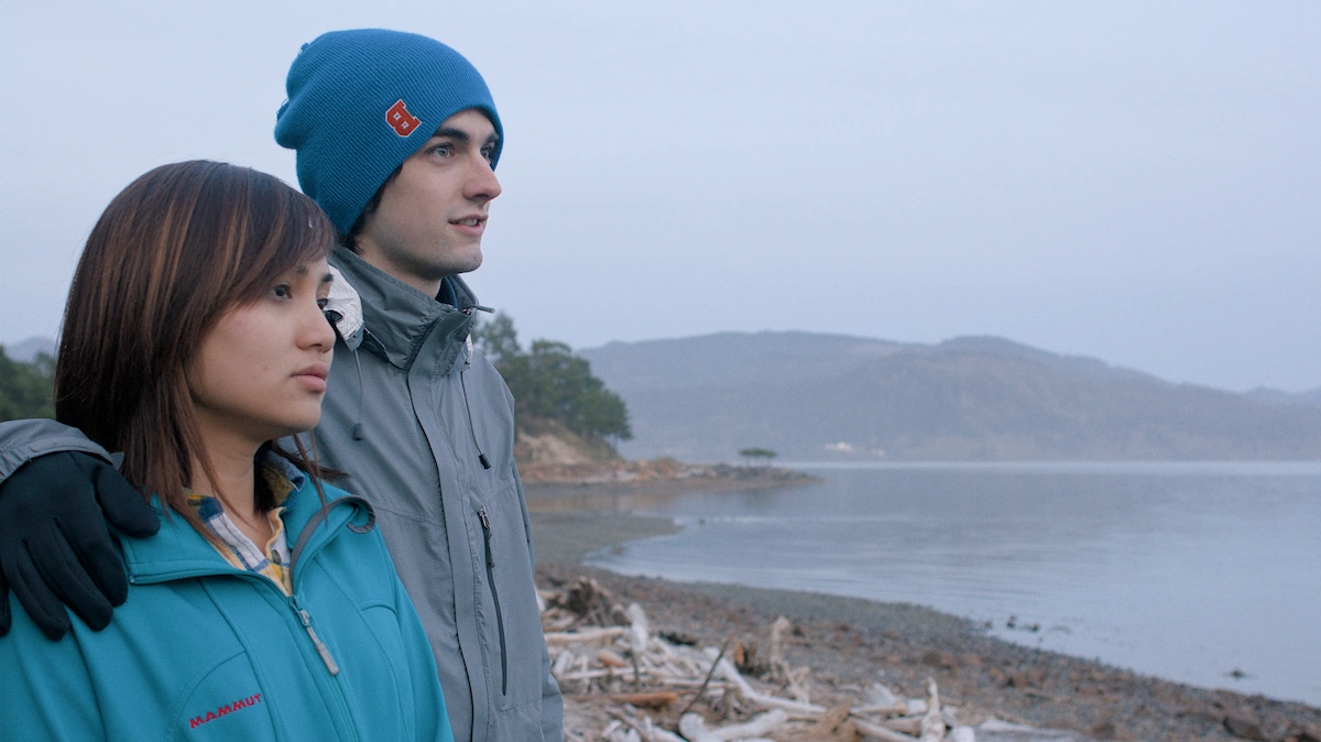 A man and woman look out over a bay along the Oregon coast